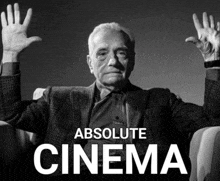 a black and white photo of a man with his hands in the air with the words absolute cinema below him