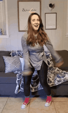 a woman dancing in front of a sign that says above all else