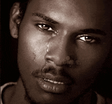 a close up of a man 's face with a tear coming out of his eye