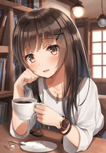 a girl is sitting at a table with a cup of coffee in her hand .