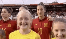 a group of female soccer players are posing for a picture and one of them has the number 10 on her shirt .