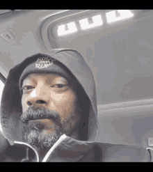 a man with a beard wearing a hoodie and a beanie with the word snoop dogg on it