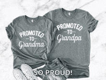 a couple of shirts that say `` promoted to grandma '' and `` promoted to grandpa '' are sitting on a table .