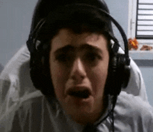 a man wearing headphones and a headset is making a funny face