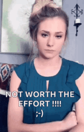 a woman in a blue shirt is making a funny face and saying `` not worth the effort !!! '' .