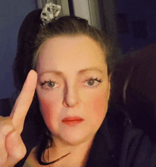 a woman with a ponytail is making a peace sign with her finger