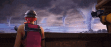 a person in a red shirt is looking at a tornado