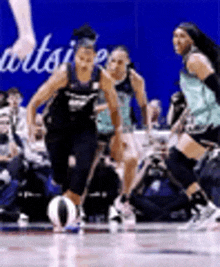 a group of female basketball players are playing a game on a court .