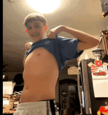 a man taking off his shirt in front of a refrigerator that has a sign on it that says ' i love you '