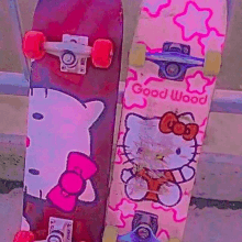 two skateboards with hello kitty on them are sitting next to each other on a sidewalk .