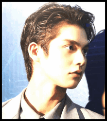 a close up of a young man 's face with a gray shirt on