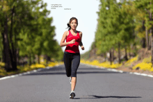 a woman in a red tank top is running down the road