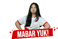 a girl making a funny face behind a sign that says " mabar yuk "