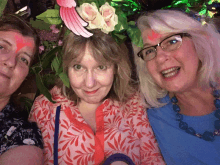 three women posing for a picture with one wearing a flower crown on her head