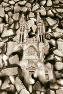 a statue of a cathedral surrounded by rocks