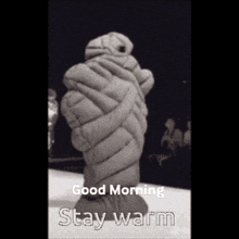 a black and white photo of a person wrapped in a blanket with the words good morning stay warm