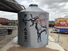 a large metal silo with the words fat ass ranch market written on it