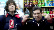 two men are standing in front of a shelf of pringles