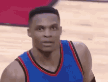 a close up of a basketball player wearing a blue and red jersey on a basketball court .