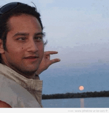 a man is pointing at the moon with his finger