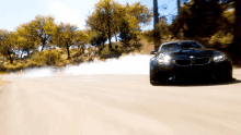 a black bmw is driving down a road with smoke coming out of its tires