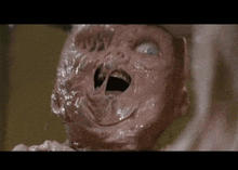 a close up of a baby 's face with its mouth open in a movie .