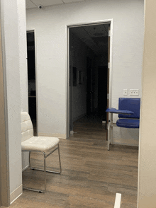 a white chair sits in a hallway next to two blue chairs