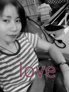 a black and white photo of a woman with the word love written on her arm