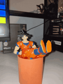 a figurine of goku is laying on his back in a cup