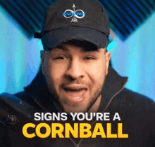 a man wearing a hat that says " signs you 're a cornball " on it