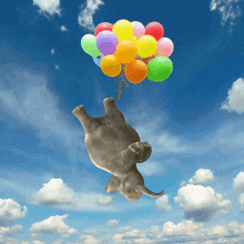 an elephant is flying through the air holding balloons