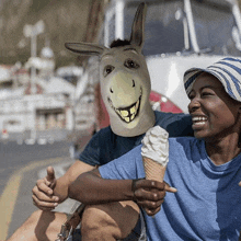 a man wearing a donkey mask holds a cone of ice cream