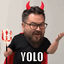 a man with horns and a trident has the word yolo on his shirt