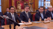 a group of men are sitting at a table with a sign that says ' republicana fiidonia ' on it