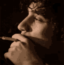 a woman is smoking a cigarette in a black and white photo .
