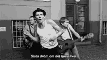 a black and white photo of a group of men playing guitars and singing .