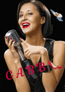 a woman singing into a microphone with the name gabba on the bottom right