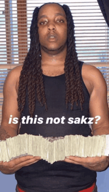 a man with dreadlocks is holding a large stack of money with the caption " is this not sakz "