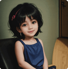 a little girl wearing a blue dress and a pink headband