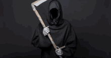 a grim reaper in a black robe is holding a scythe .