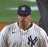 a new york yankees baseball player wearing a striped jersey and a hat