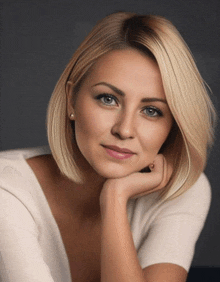 a woman in a white shirt with her hand on her face