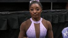 a woman wearing a purple leotard with the word xtf on the back