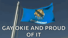 a blue flag with oklahoma written on it is flying in the wind