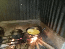 an oppo a16k shows a picture of pots and pans cooking over a fire