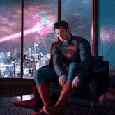 a man in a superman costume is sitting on a chair