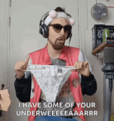 a man is wearing headphones and holding a pair of underwear .