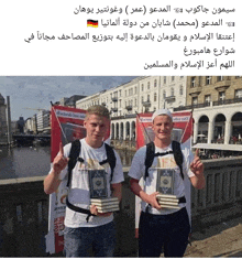 two men standing next to each other holding books in front of a sign that says ' marlboro '