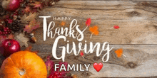 a wooden table topped with pumpkins , apples , leaves and berries with the words `` happy thanksgiving family '' .