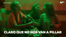 a group of women are sitting in a dark room with the words claro que no nos van a pillar in the corner .